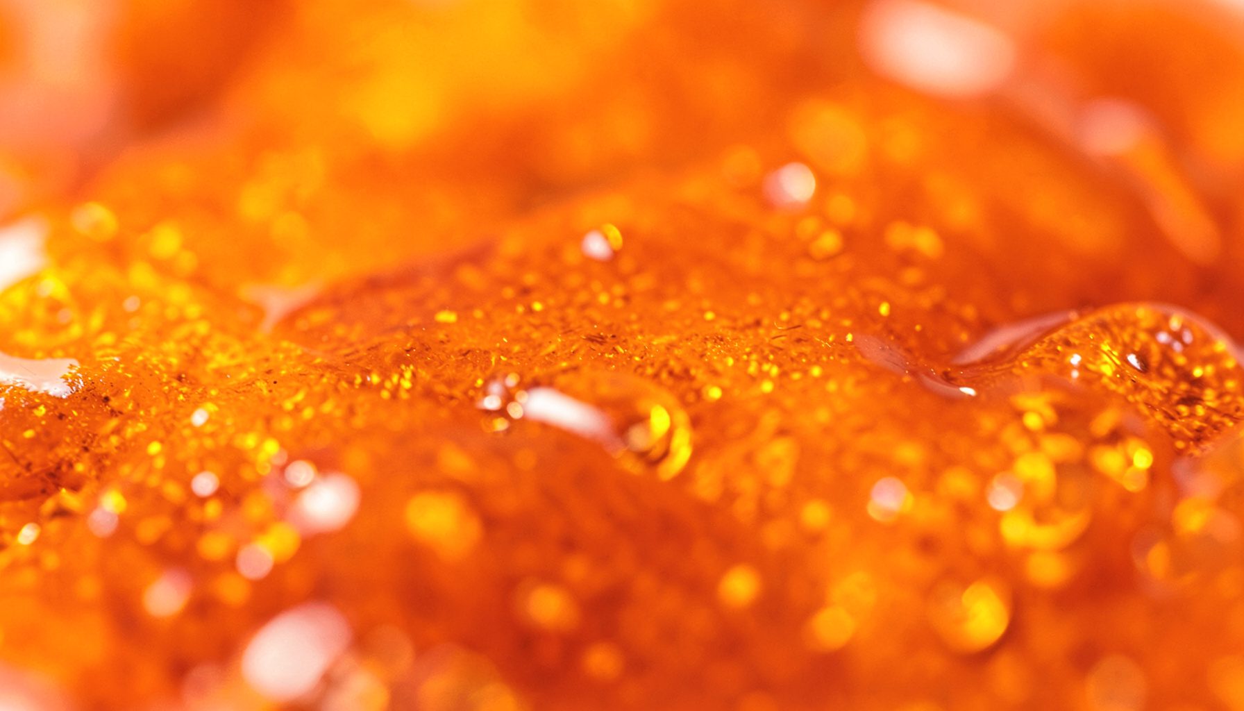 Golden amber honey oil texture with glossy surface and warm orange-brown tones